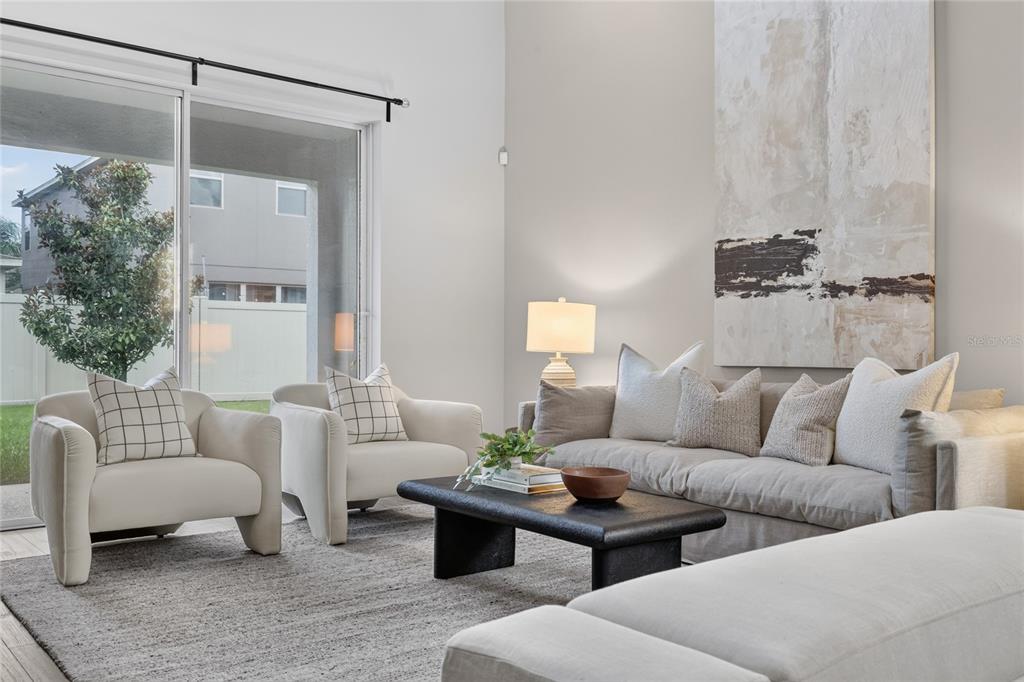 A living room features a sofa, two armchairs, a coffee table, and large sliding doors — 517 RED ROSE LANE, SANFORD, FL