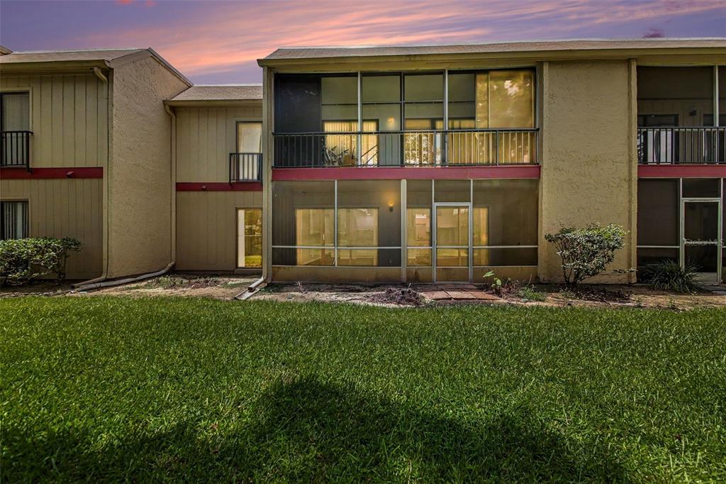 Exterior view of a two-story apartment building with a screened-in patio and upper balcony — 429 SHEOAH BOULEVARD UNIT 9, WINTER SPRINGS, FL