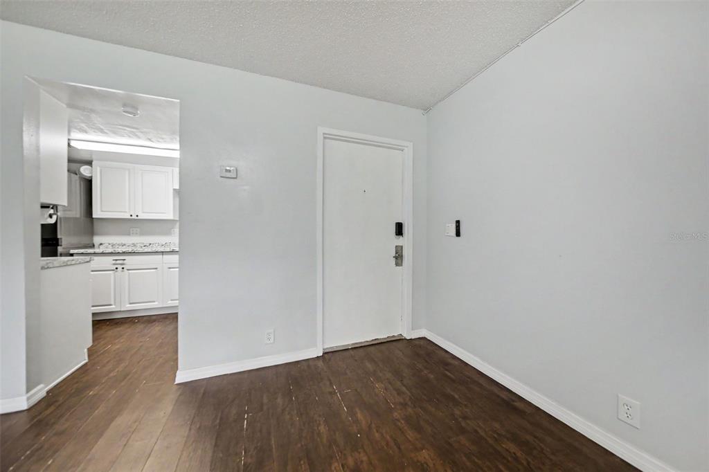 A room with dark wood-look flooring, light gray walls, and a white door — 429 SHEOAH BOULEVARD UNIT 9, WINTER SPRINGS, FL
