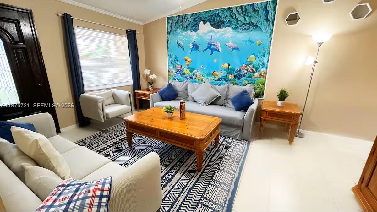 A living room features a large underwater mural, two sofas, and a wooden coffee table — 404 Red Hawk Loop, Winter Haven FL 33880, WINTER HAVEN, FL