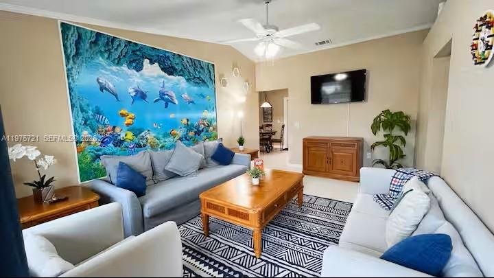 A living room features a large underwater mural, two sofas, and a wooden coffee table — 404 Red Hawk Loop, Winter Haven FL 33880, WINTER HAVEN, FL