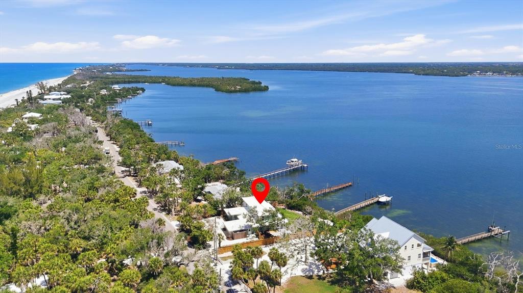 An aerial view shows a waterfront house with a private dock on a bay — 6421 MANASOTA KEY ROAD, ENGLEWOOD, FL