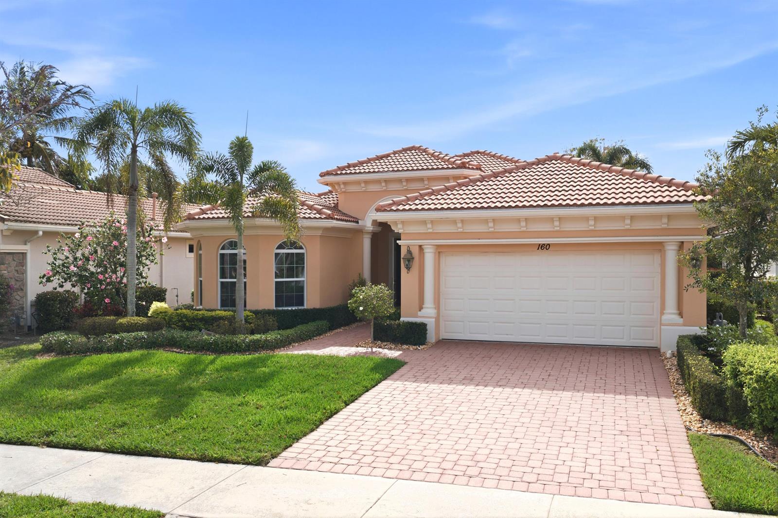 A single-story house with a peach exterior, tile roof, and a paved driveway — 160 Carina Drive, Jupiter FL 33478, JUPITER, FL