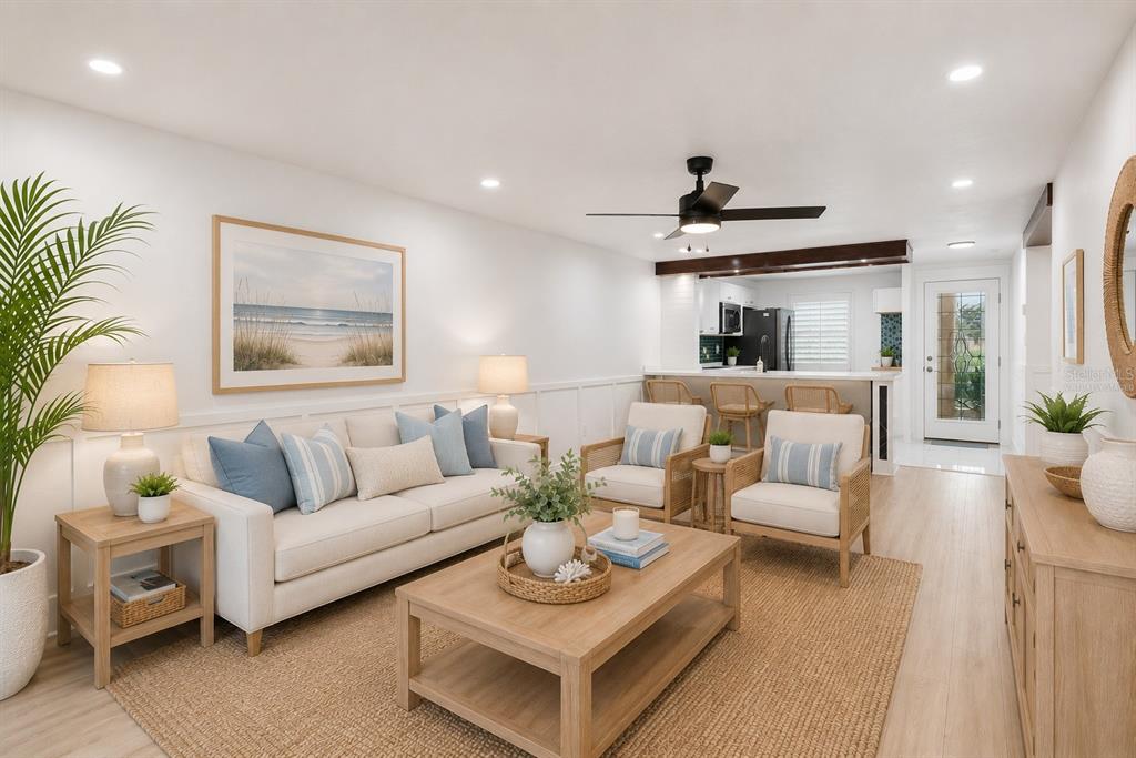 A bright living room features a white sofa, two armchairs, and a kitchen breakfast bar — 4368 SUMMERSUN DRIVE UNIT 4368, NEW PORT RICHEY, FL