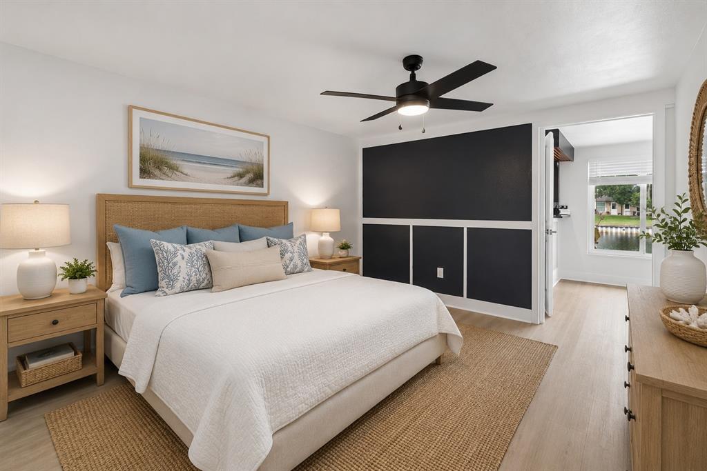 A bedroom features a king bed, a black accent wall, and a view of water — 4368 SUMMERSUN DRIVE UNIT 4368, NEW PORT RICHEY, FL