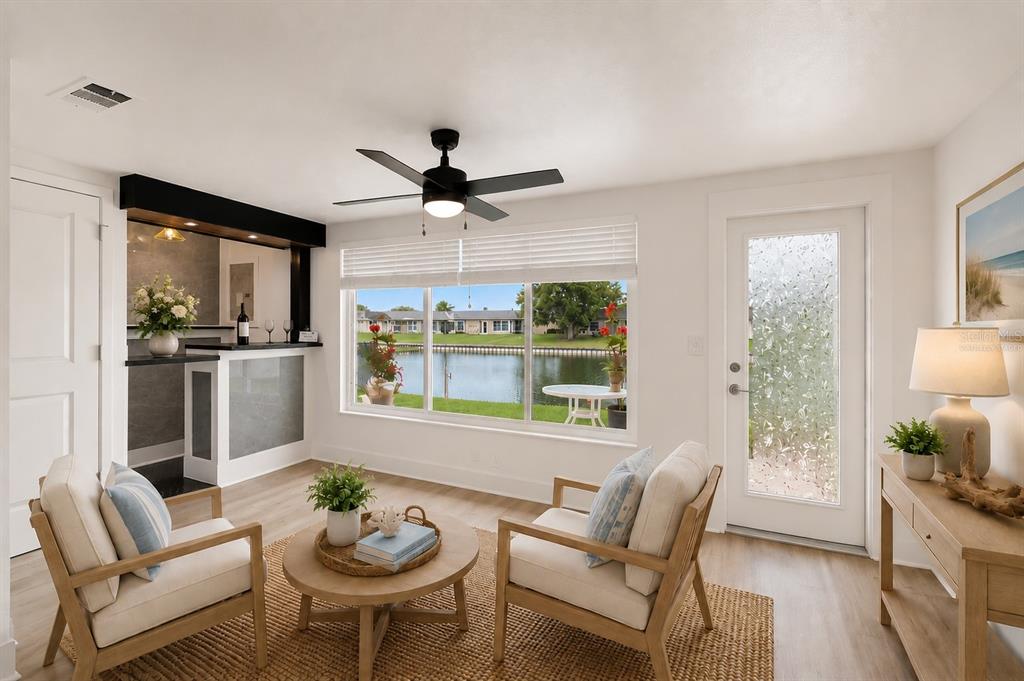 A living room features a wet bar, two armchairs, a coffee table, and a water view — 4368 SUMMERSUN DRIVE UNIT 4368, NEW PORT RICHEY, FL