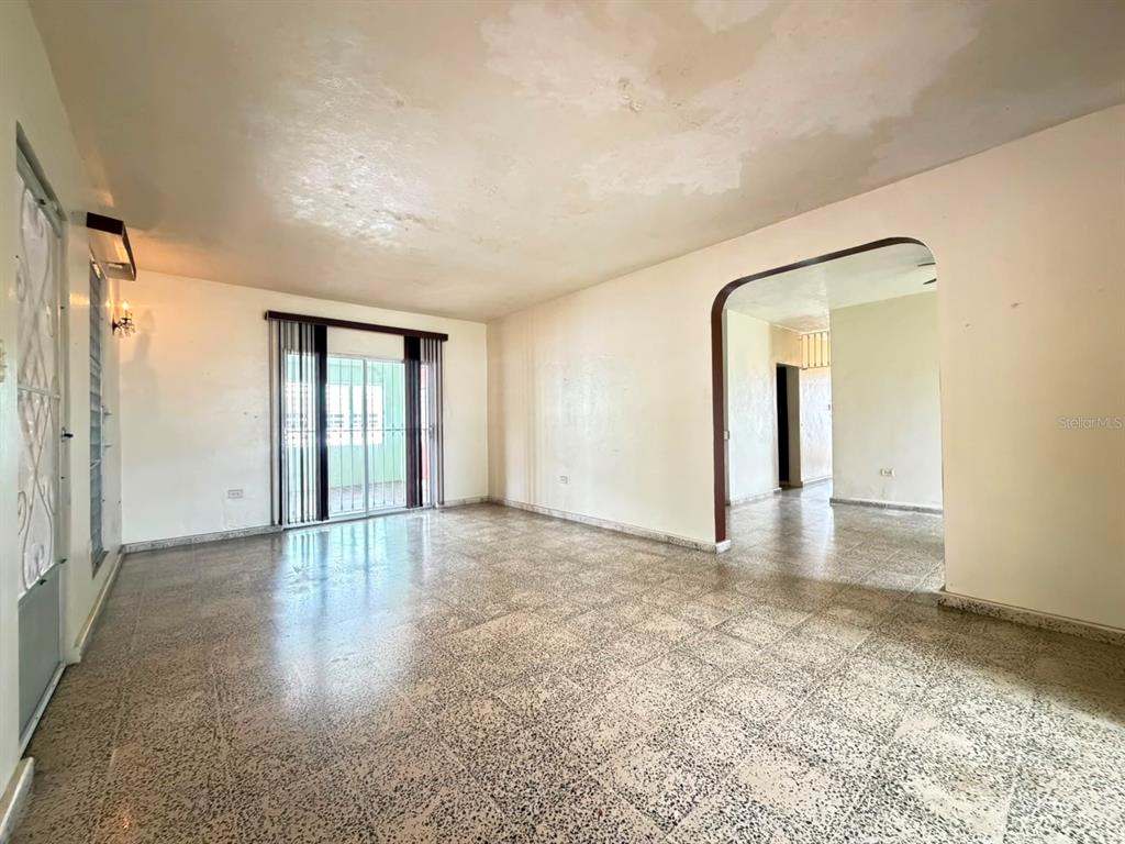 An empty room with speckled tile flooring, white walls, and a large arched doorway — PR 917 KM 1.8, LAS PIEDRAS, PR