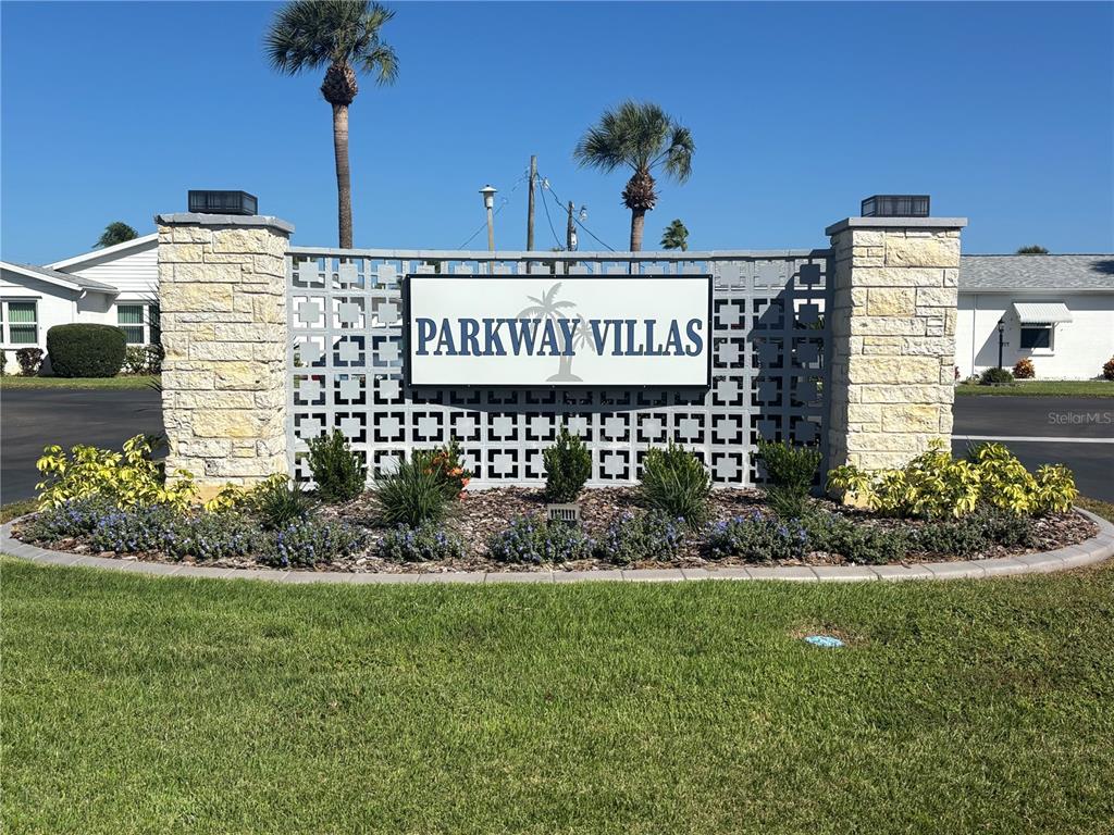 A stone monument sign for Parkway Villas stands in a landscaped lawn area — 5983 CORAL WAY, BRADENTON, FL