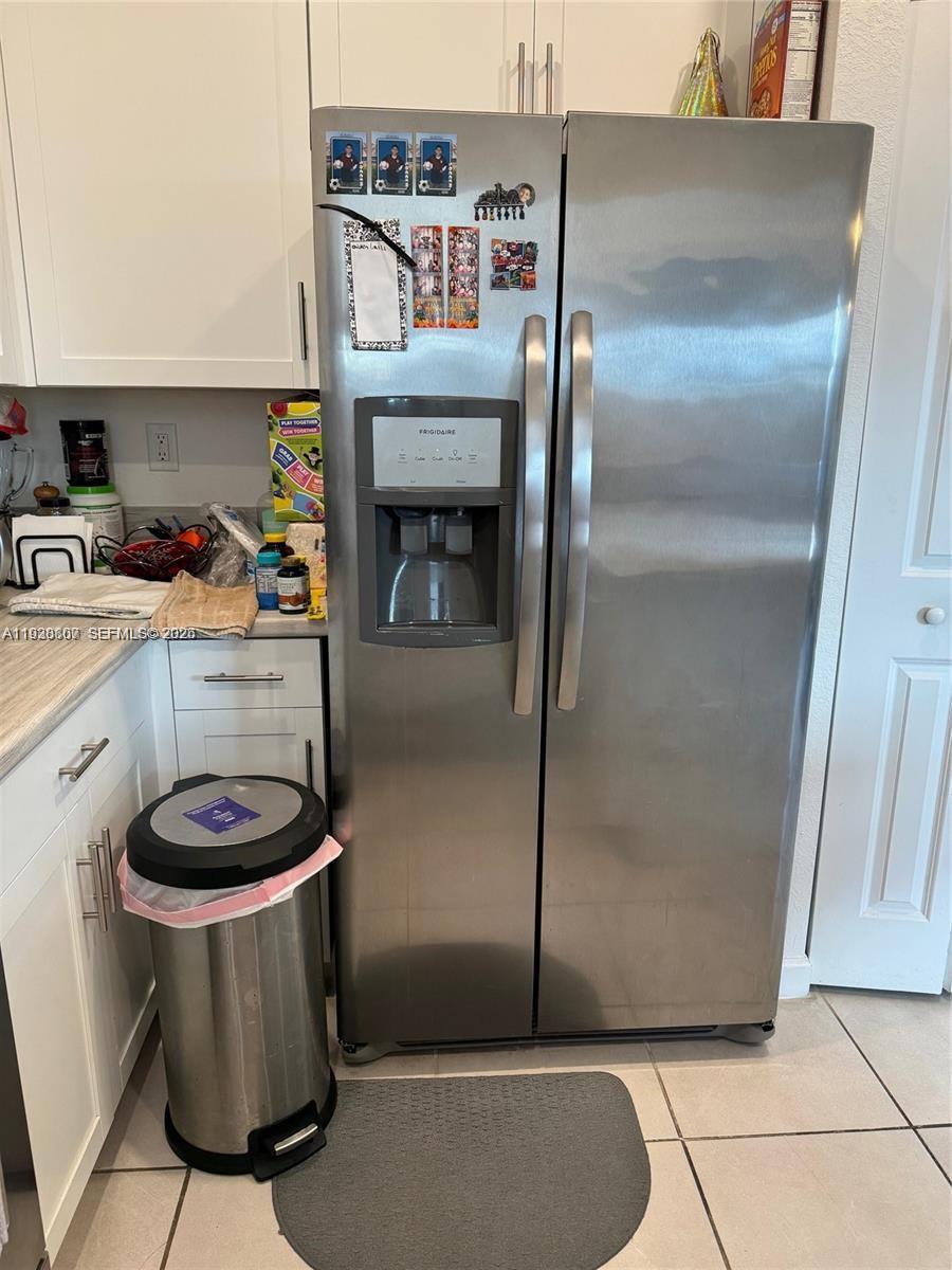 A kitchen features white cabinets, a stainless steel side-by-side refrigerator, and a trash can — 21441 NE 3rd Pl, Miami FL 33179, MIAMI, FL