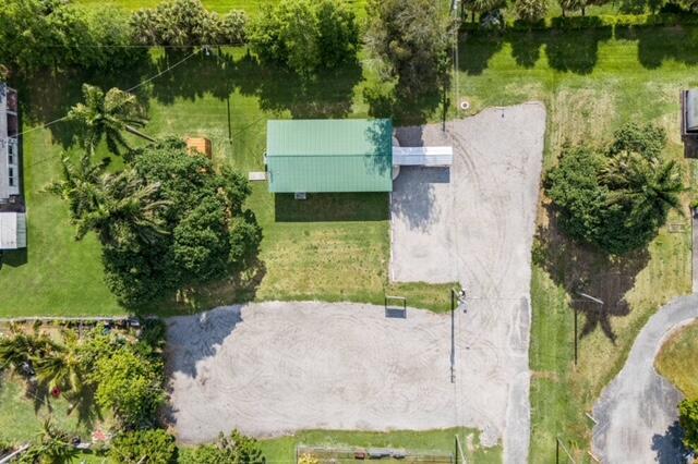 An aerial view shows a building with a green metal roof surrounded by trees and gravel — 224 NW G Avenue, Belle Glade FL 33430, BELLE GLADE, FL