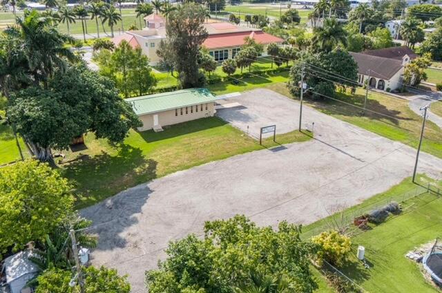 An aerial view shows a small building with a green roof next to a gravel lot — 224 NW G Avenue, Belle Glade FL 33430, BELLE GLADE, FL