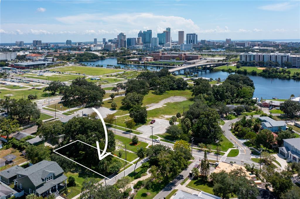 An aerial view shows a vacant, tree-lined lot outlined in white near a city skyline — 2203 GLENWOOD, TAMPA, FL