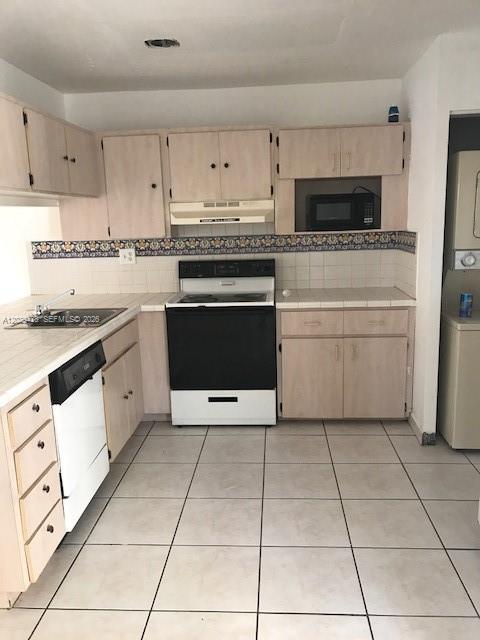 A kitchen features light wood cabinets, white tile countertops, a black stove, and tiled floors — 15401 SW 81st Cir Ln # 16, Miami FL 33193, MIAMI, FL