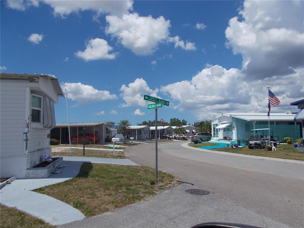 A street view of a mobile home community with a street sign and American flag — 6706 SAGE LANE, NORTH PORT, FL