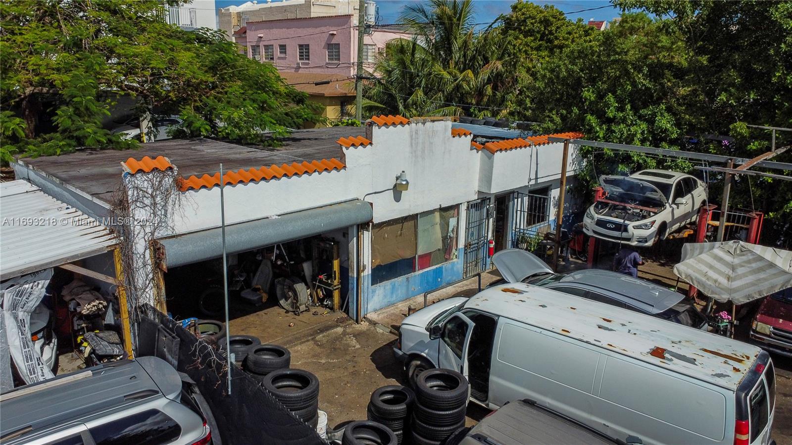 An exterior view of an auto repair shop with a white facade and orange tiles — 1535 W Flagler St, Miami FL 33135, MIAMI, FL