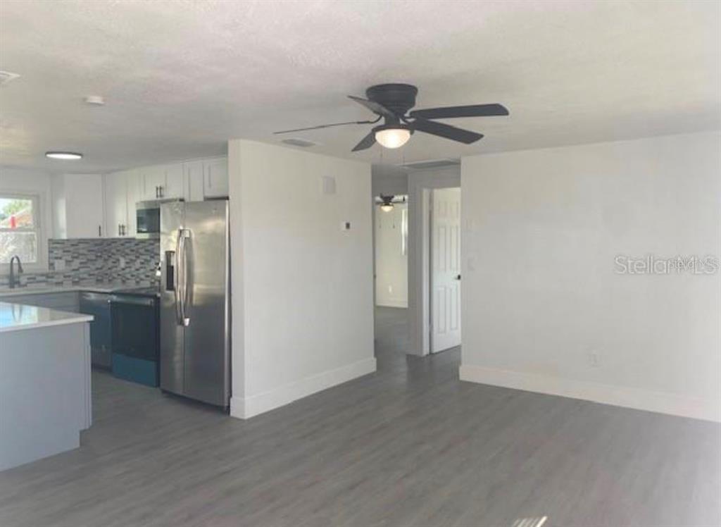 A kitchen island with gray cabinets and a light countertop sits in a white room — 4803 GUARDIAN AVENUE, HOLIDAY, FL