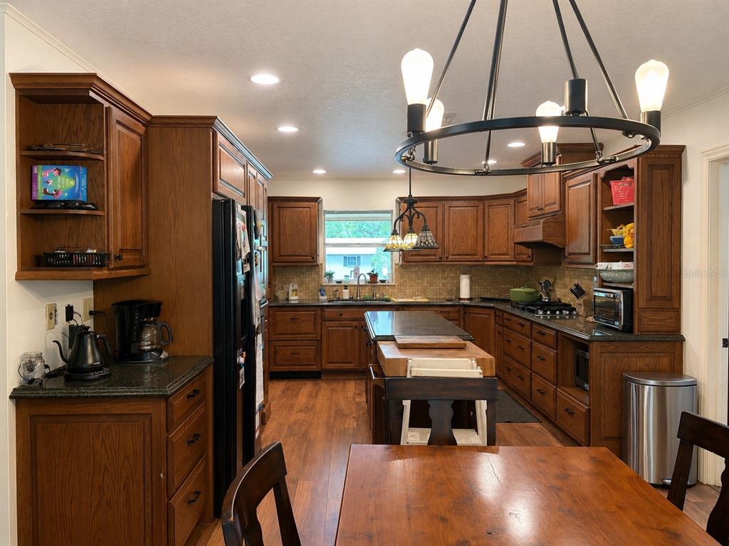 A kitchen with wood cabinets, a central island, and a large circular chandelier — 308 N SALISBURY AVENUE, DELAND, FL