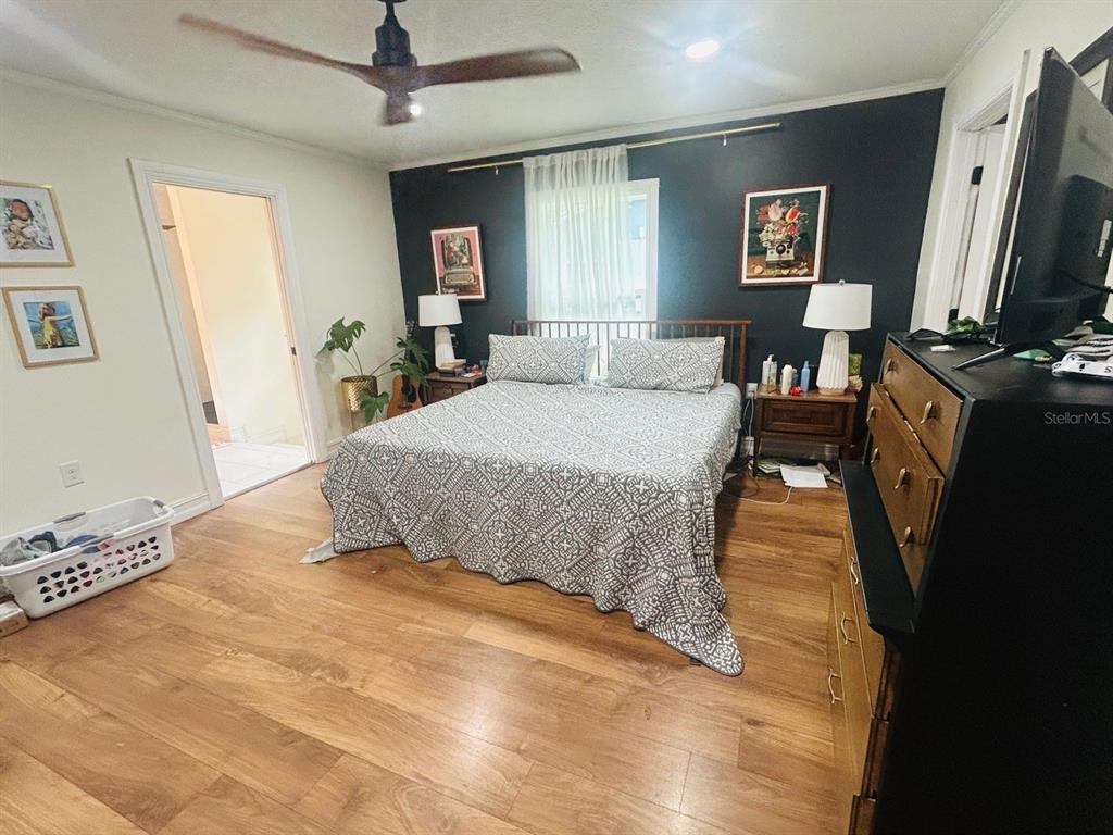 A bedroom features a bed with a patterned quilt against a dark accent wall — 308 N SALISBURY AVENUE, DELAND, FL
