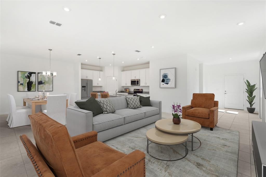 An open-concept living and dining area features white cabinetry, a gray sofa, and leather chairs — 926 CASTLEFORD AVENUE NE, PALM BAY, FL