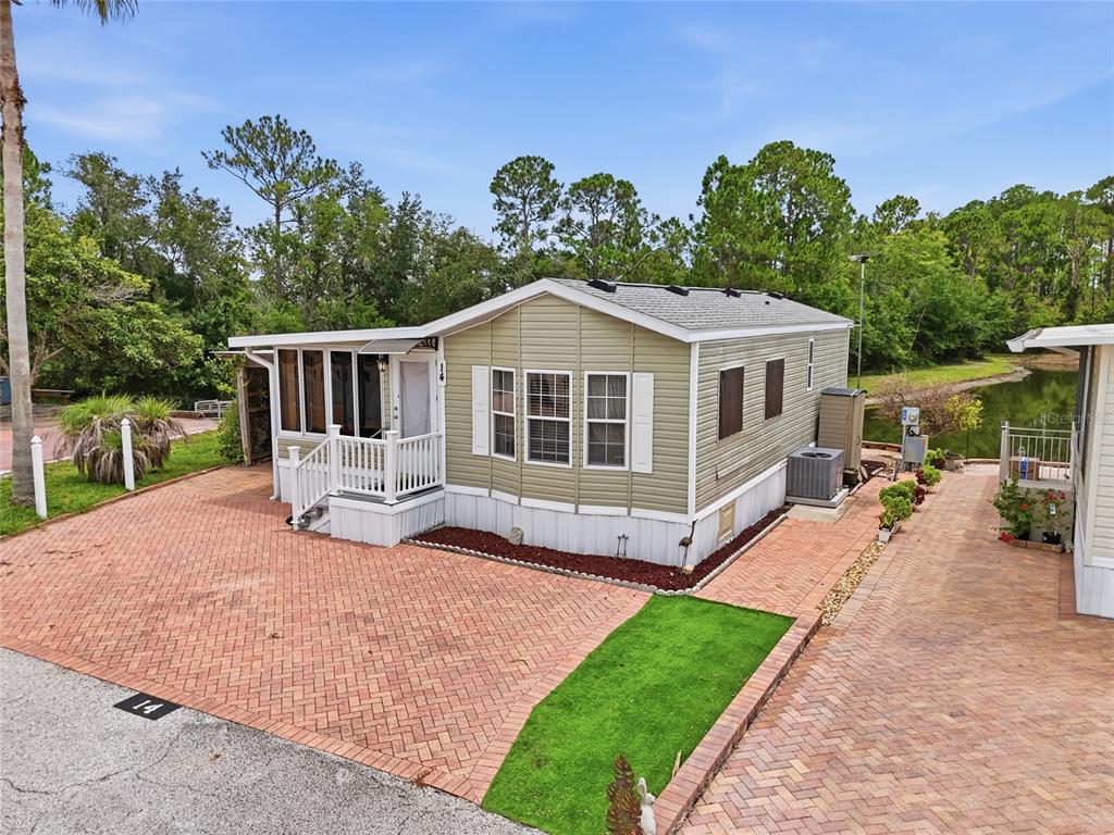 A light green manufactured home with a brick driveway and a small front porch — 20285 US HIGHWAY 27 UNIT 14, CLERMONT, FL
