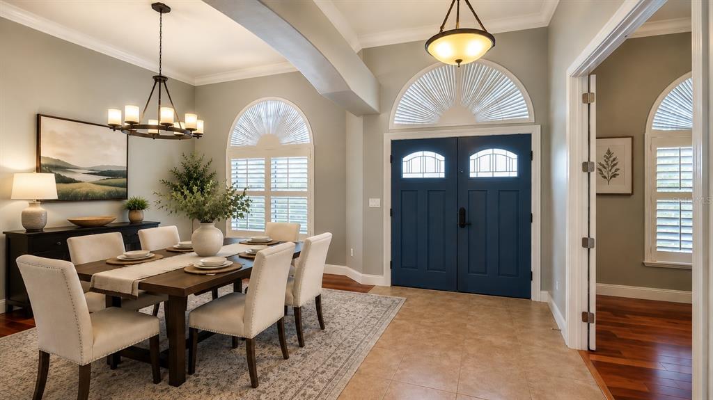 A dining room with a wooden table, chairs, and blue double front doors — 6070 SABAL CREEK BOULEVARD, PORT ORANGE, FL