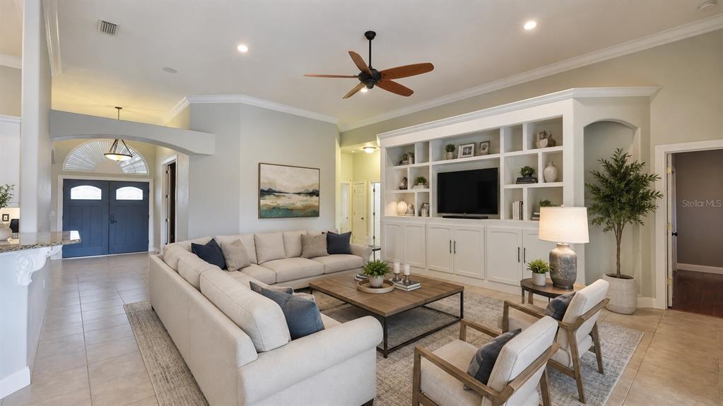 A living room features a large sectional sofa, two armchairs, and a built-in media center — 6070 SABAL CREEK BOULEVARD, PORT ORANGE, FL