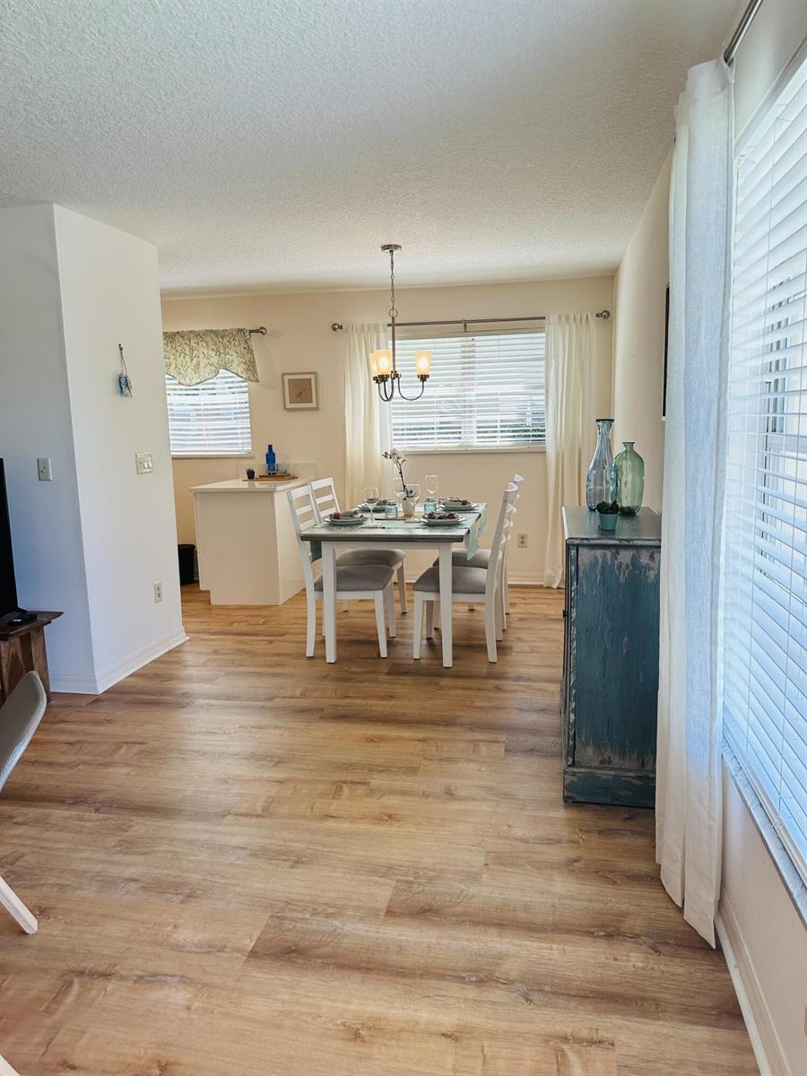 A dining area features a table with four chairs, light wood flooring, and a blue cabinet — 80 Crooked Tree Lane, Vero Beach FL 32962, VERO BEACH, FL