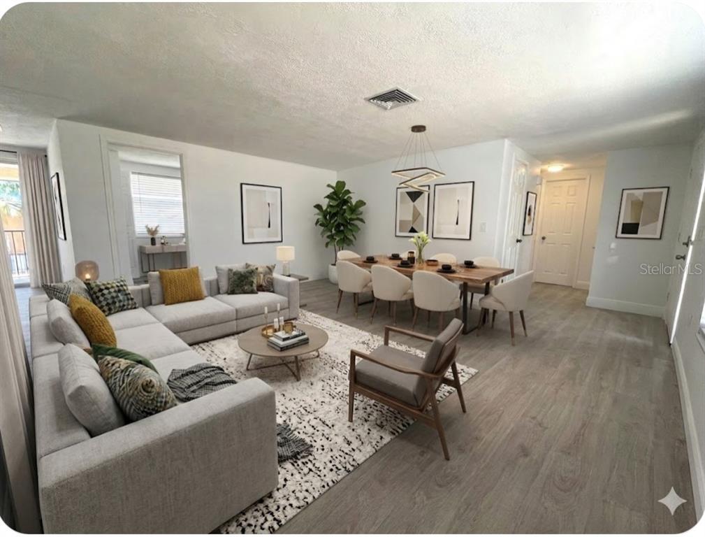 An open-concept living and dining room with light wood flooring and neutral furniture — 6646 ALBEMARLE PARKWAY, NEW PORT RICHEY, FL