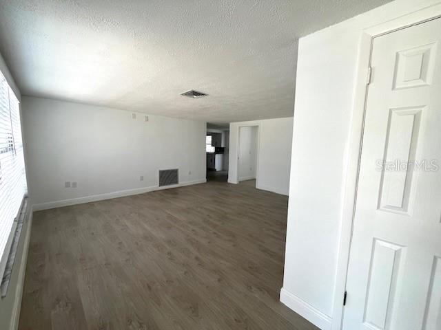 An interior view of a room with light wood-look flooring and white walls — 6646 ALBEMARLE PARKWAY, NEW PORT RICHEY, FL