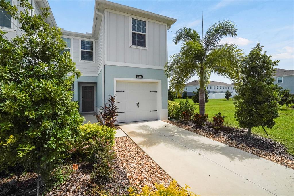 A two-story house with a light blue exterior, a single-car garage, and a palm tree — 14229 CRIMSON AVENUE, LAKEWOOD RANCH, FL