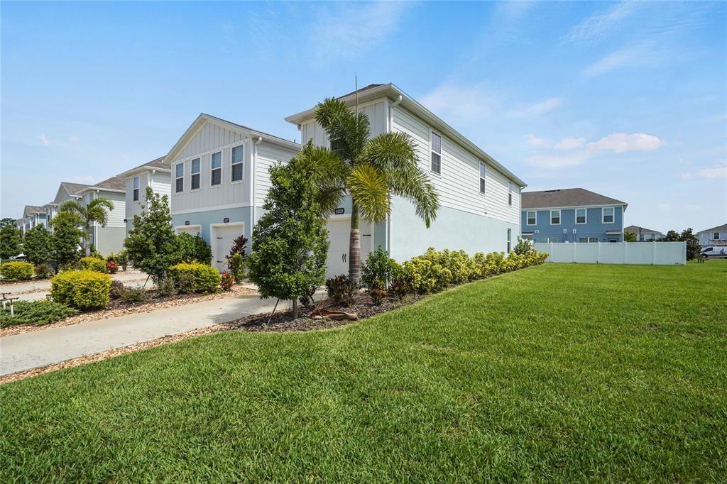 A two-story light-colored house with a palm tree and a side lawn — 14229 CRIMSON AVENUE, LAKEWOOD RANCH, FL