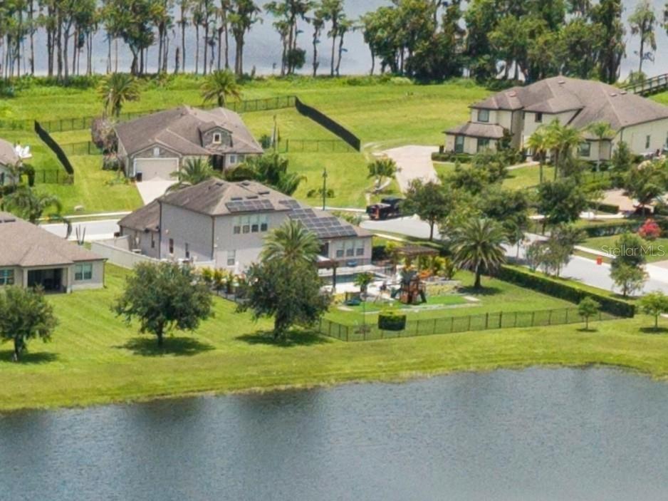 An aerial view of a two-story house with solar panels, a pool, and two pergolas — 17626 SAILFIN DRIVE, ORLANDO, FL