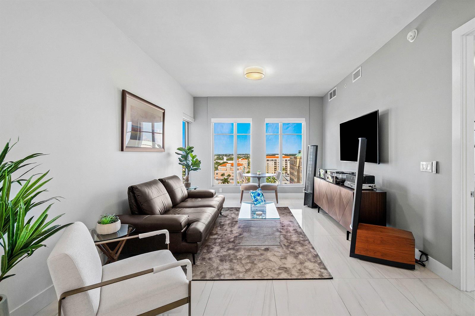 A modern living room features a leather sofa, glass coffee table, and large windows with views — 155 E Boca Raton Road # 1119, Boca Raton FL 33432, BOCA RATON, FL