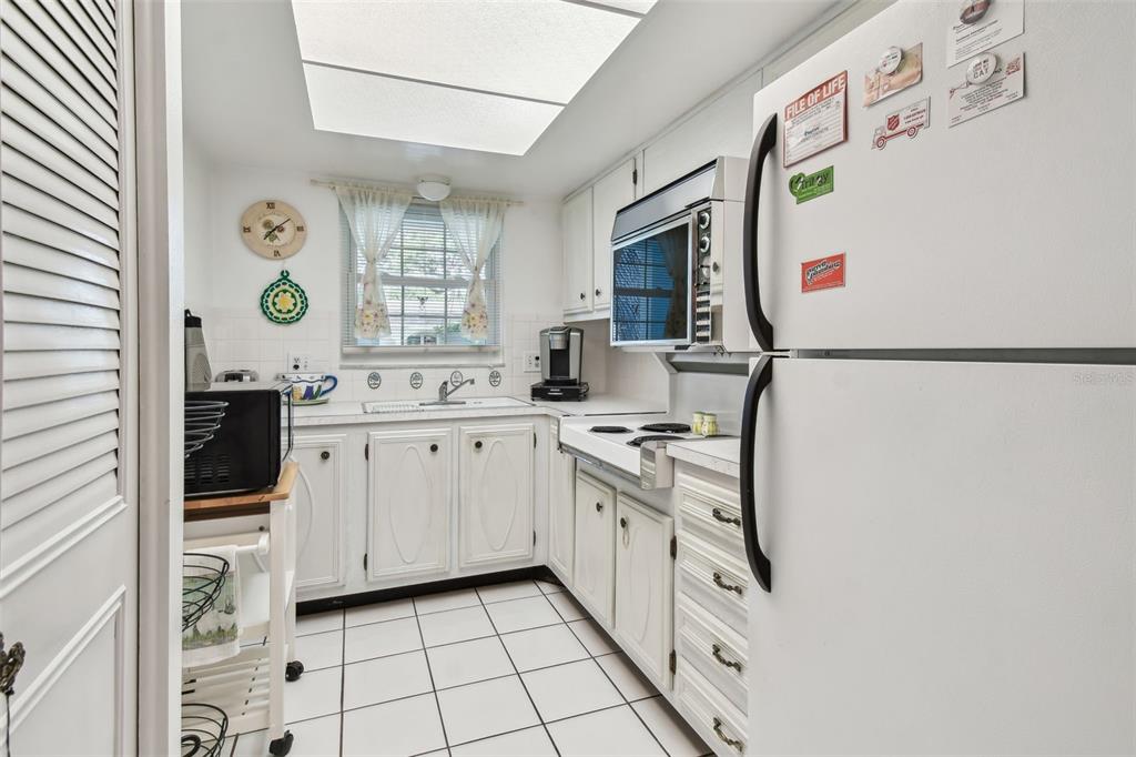 A bedroom features a double bed, a single bed, a wooden dresser, and a ceiling fan — 11200 102ND AVENUE UNIT 48, SEMINOLE, FL