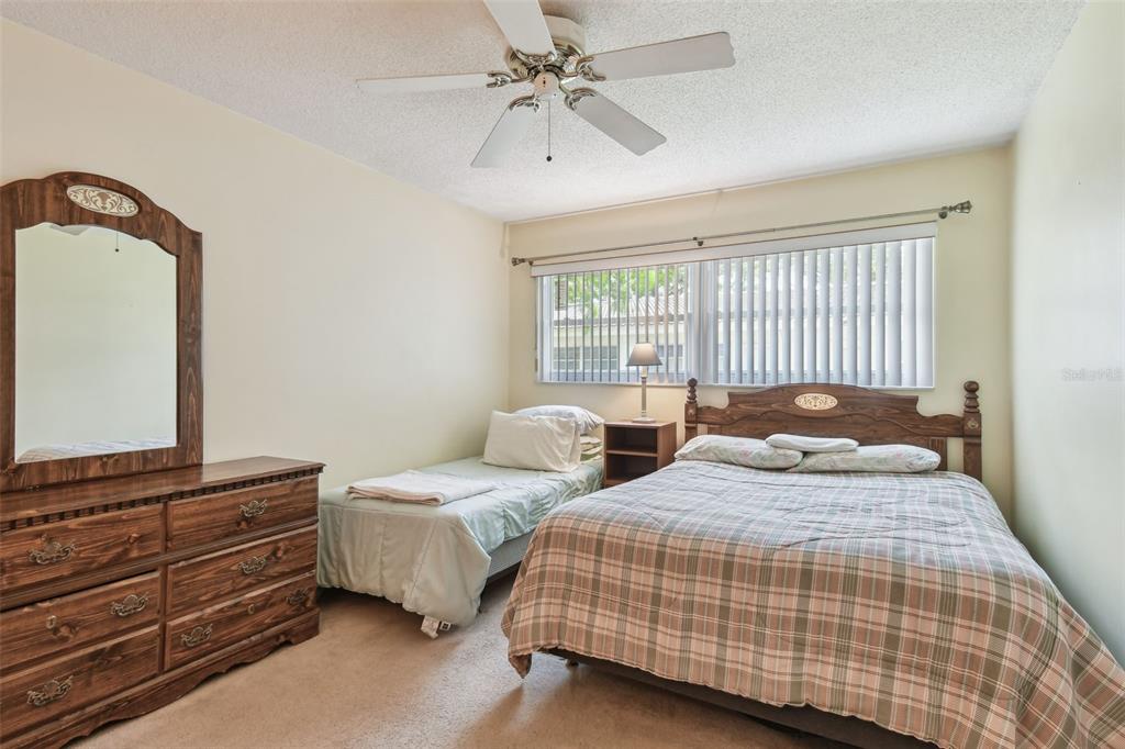 A hallway with checkered tile flooring leads to a living area with carpeted floors — 11200 102ND AVENUE UNIT 48, SEMINOLE, FL