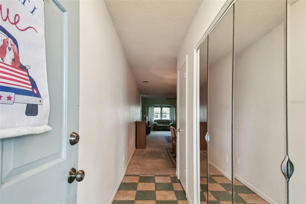 A dining area with a wooden table and hutch opens into a carpeted living room — 11200 102ND AVENUE UNIT 48, SEMINOLE, FL