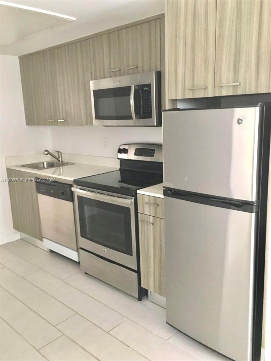 A kitchen features stainless steel appliances, light wood cabinets, and light-colored tile flooring — 740 Meridian Ave # 17, Miami Beach FL 33139, MIAMI BEACH, FL