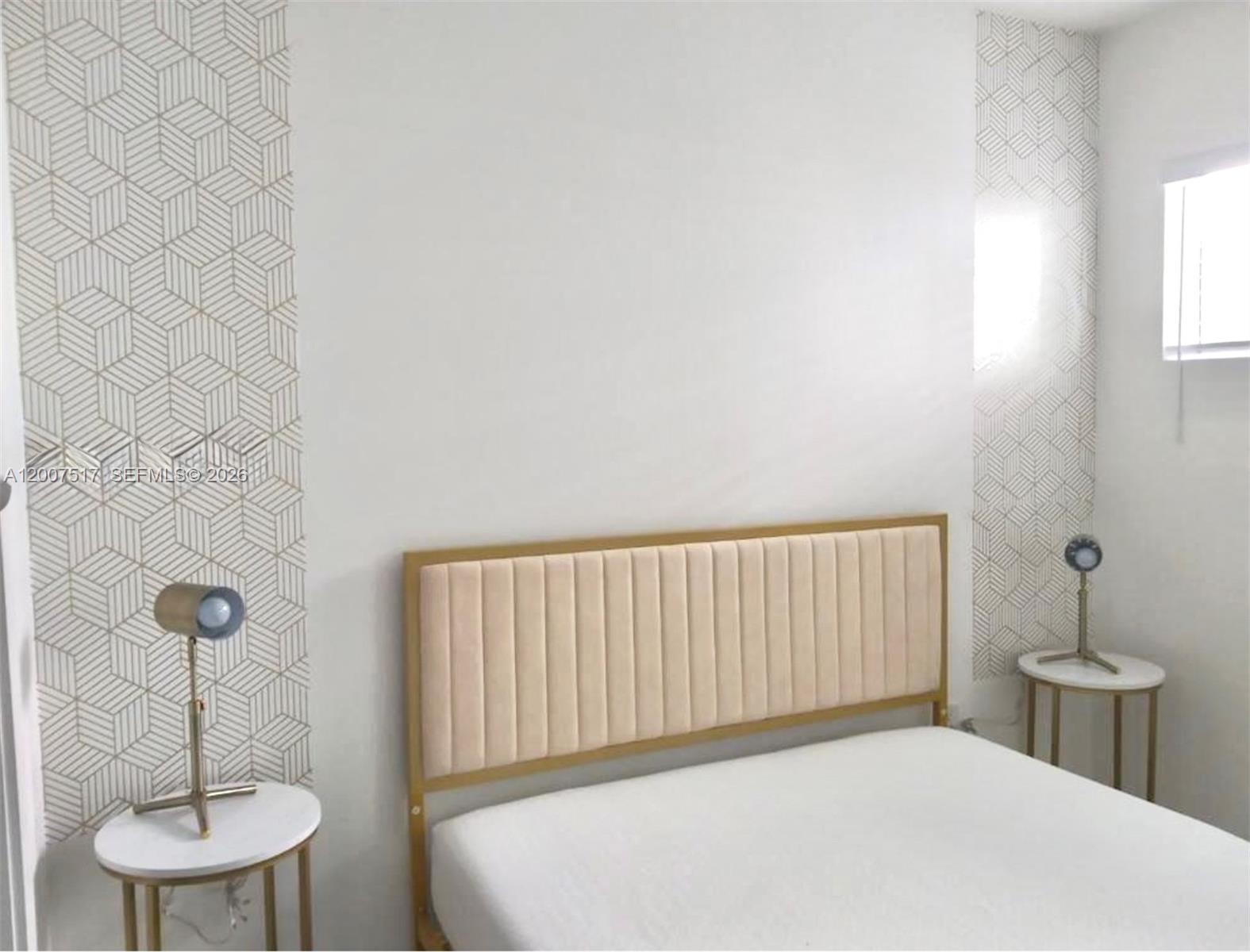A bedroom features a bed with a gold-framed headboard flanked by two patterned wallpaper panels — 740 Meridian Ave # 17, Miami Beach FL 33139, MIAMI BEACH, FL