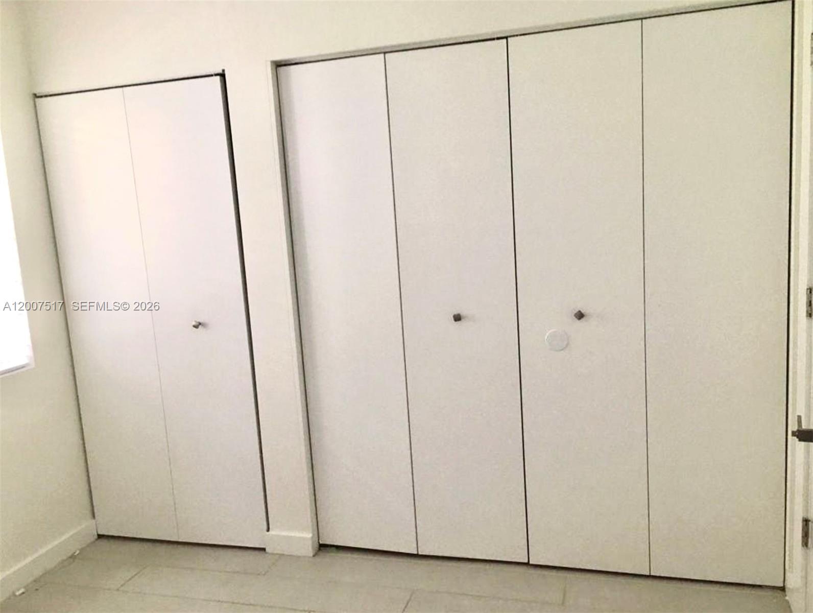 A room features white walls, light-colored flooring, and two sets of white bi-fold closet doors — 740 Meridian Ave # 17, Miami Beach FL 33139, MIAMI BEACH, FL
