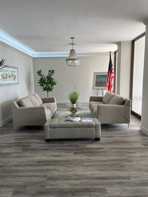 A living room features two beige sofas, a central ottoman, and a hanging light fixture — 2828 N ATLANTIC AVENUE UNIT 1601, DAYTONA BEACH, FL