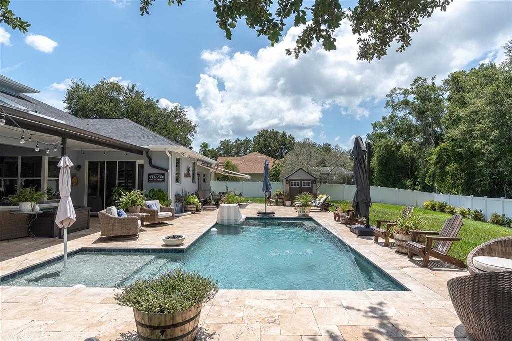 A backyard features a swimming pool with a tanning ledge, patio furniture, and a shed — 1805 MOUNTAIN ASH WAY, TRINITY, FL