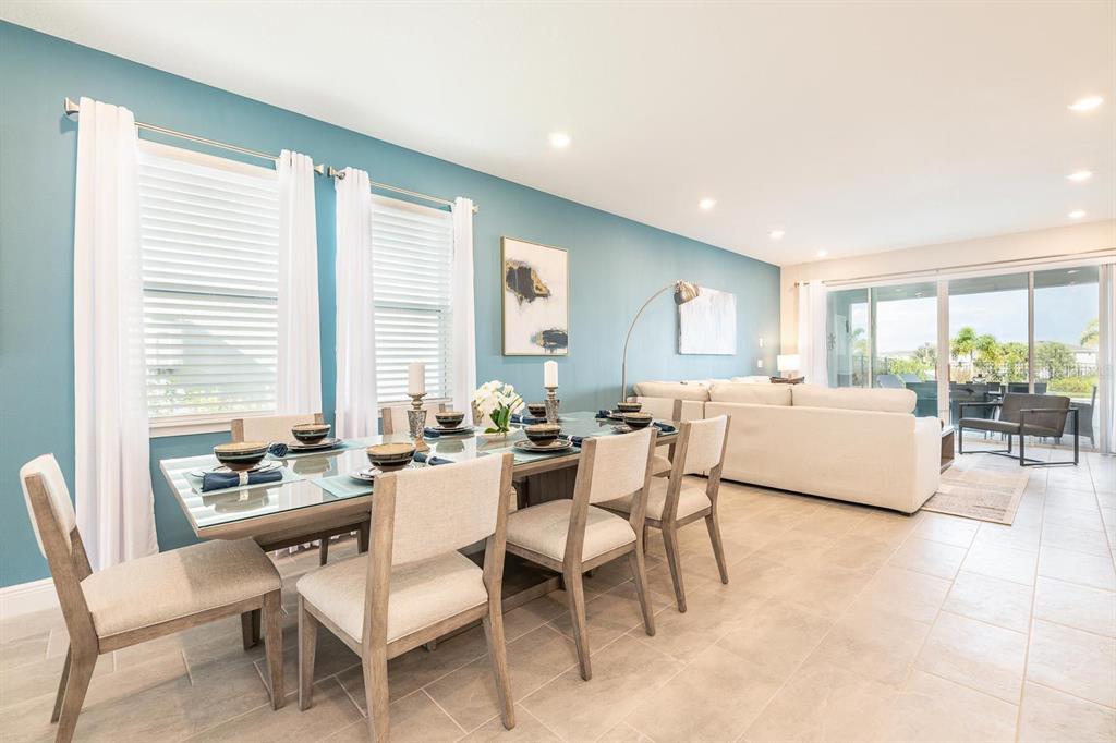A dining area with a glass table and chairs sits next to a living room — 428 SOUTHFIELD STREET, KISSIMMEE, FL