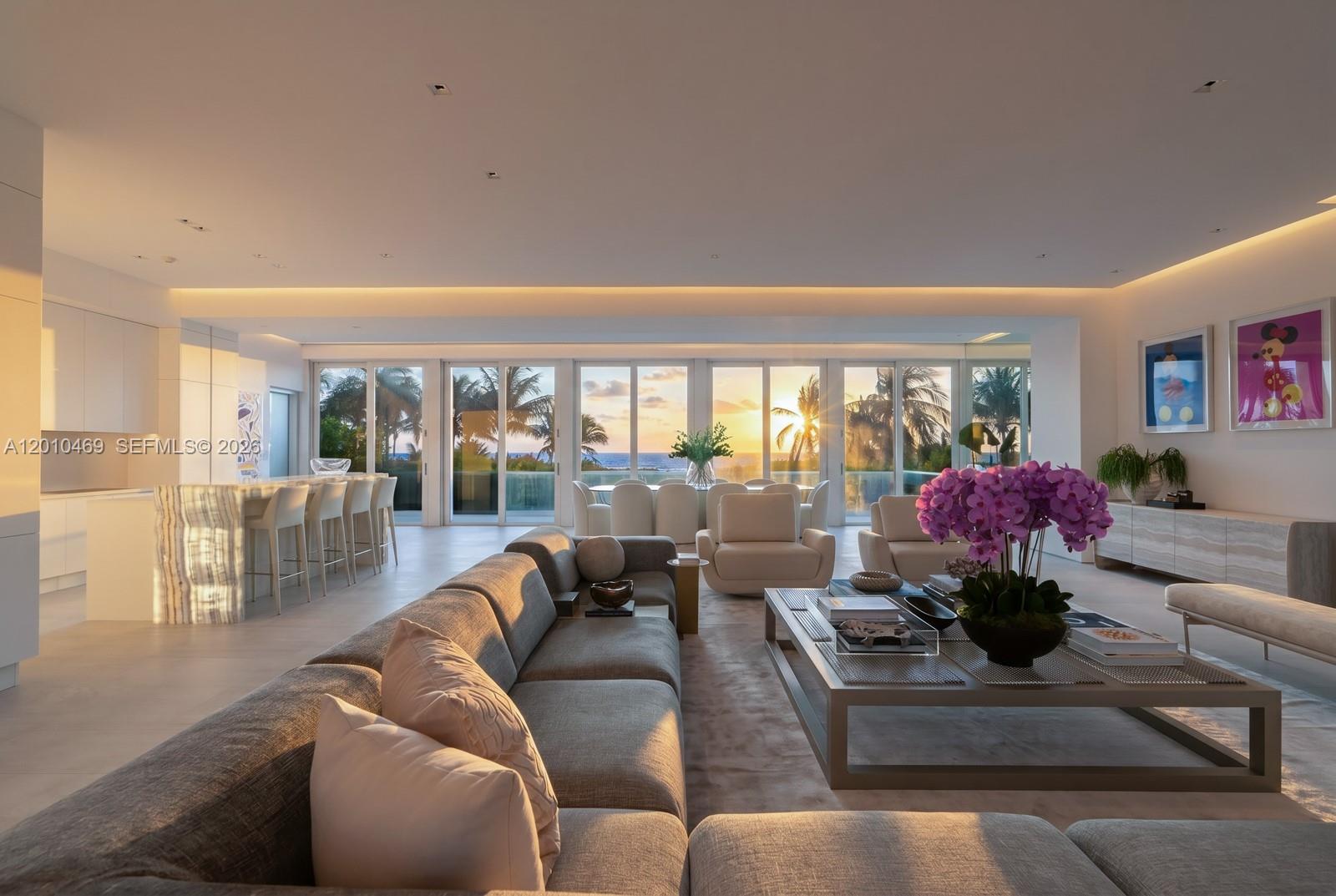 A modern open-plan living room features a kitchen island, dining area, and ocean sunset views — 7815 Atlantic Way, Miami Beach FL 33141, MIAMI BEACH, FL