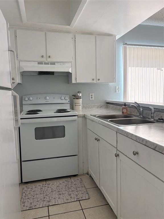A kitchen features white cabinets, a white electric range, and a marble-patterned countertop — 13045 LONDONDARY PLACE, TAMPA, FL