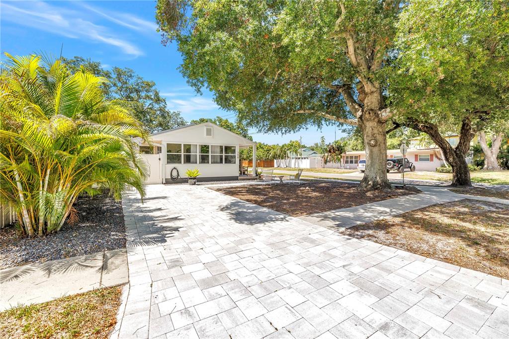 A paved driveway leads to a single-story house with a large tree in the yard — 798 45TH AVENUE N, ST PETERSBURG, FL