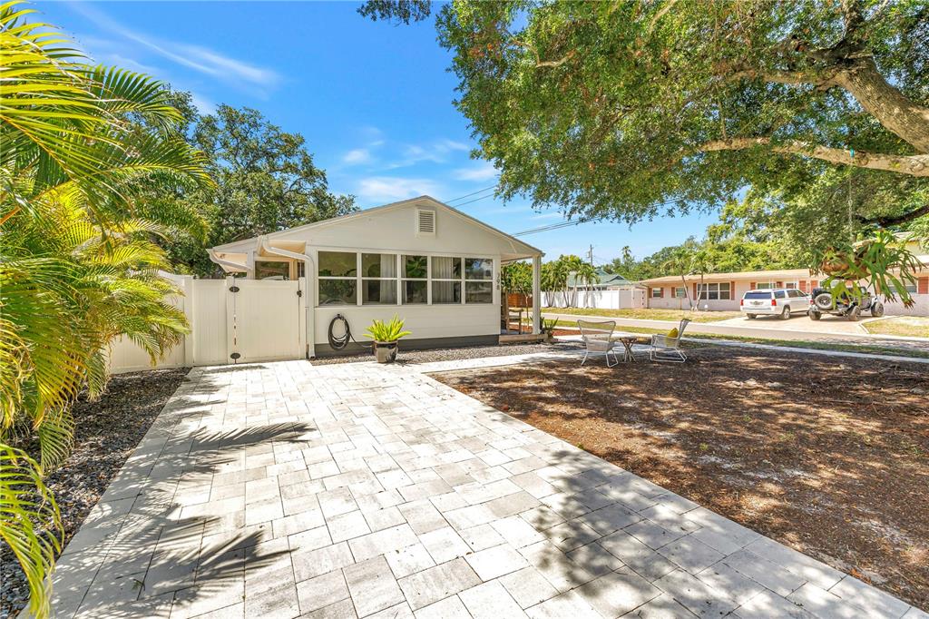 A white house with a paved patio and a large tree in the front yard — 798 45TH AVENUE N, ST PETERSBURG, FL