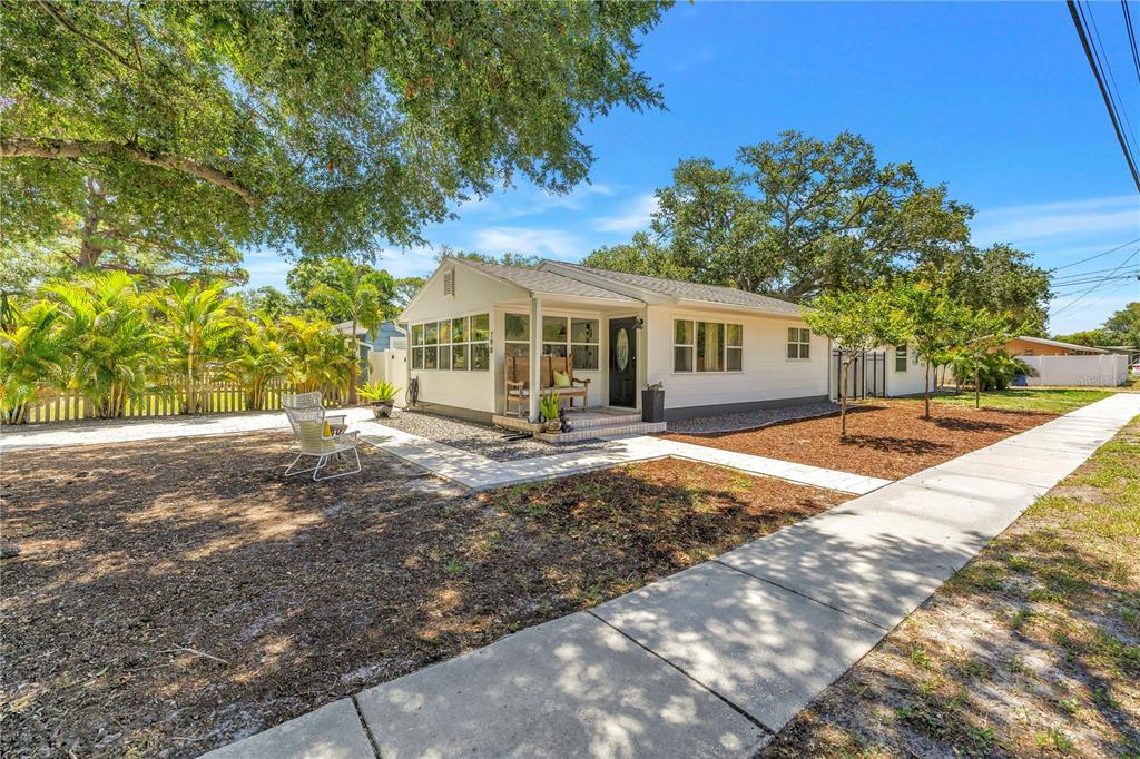 A white single-story house with a front porch and a sidewalk in the foreground — 798 45TH AVENUE N, ST PETERSBURG, FL