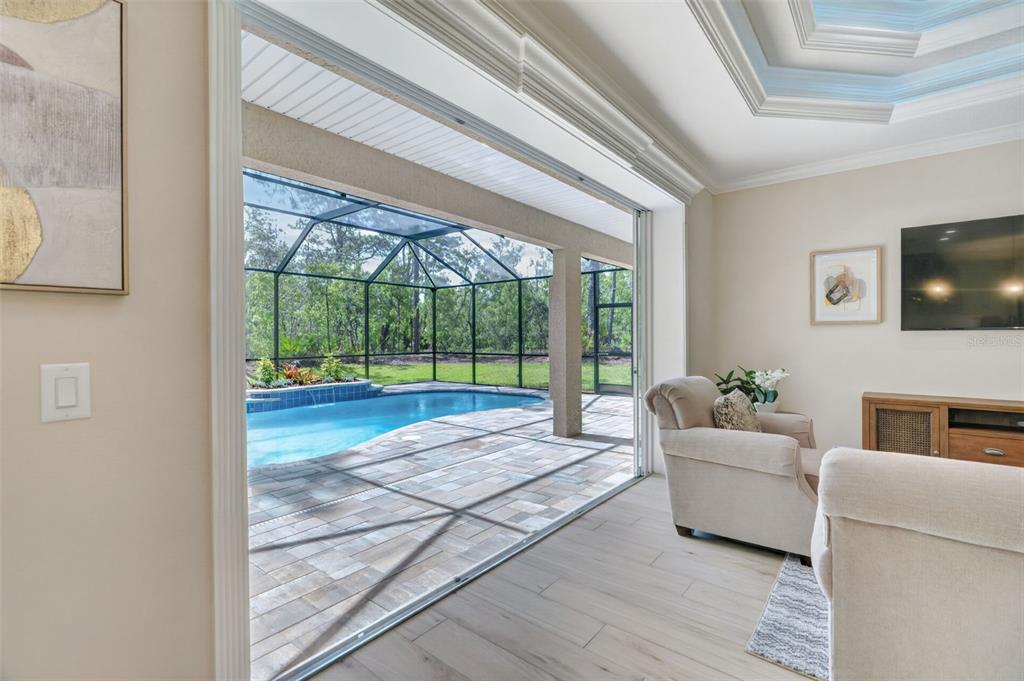 A living room opens through sliding glass doors to a screened-in patio with a pool — 5105 N PRINCEWOOD DRIVE, BEVERLY HILLS, FL