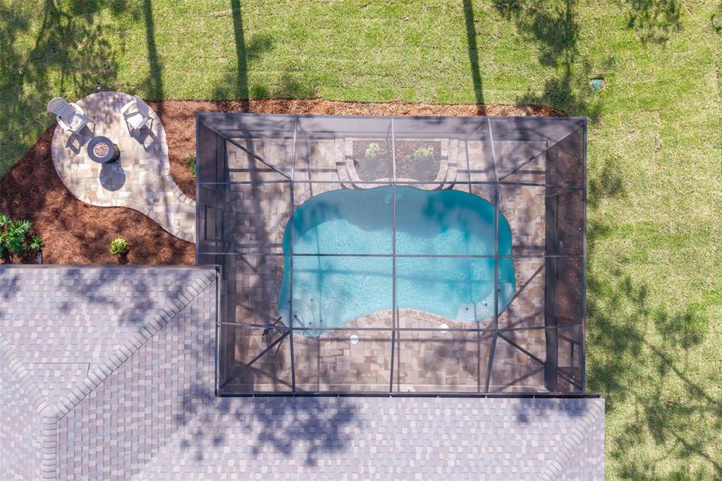 An aerial view shows a screened-in swimming pool and a paver patio with a fire pit — 5105 N PRINCEWOOD DRIVE, BEVERLY HILLS, FL