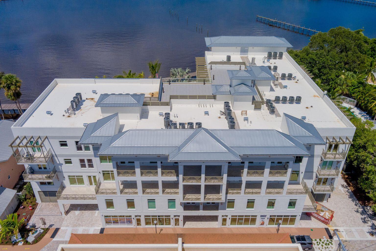 An aerial view of a multi-story building with a metal roof and ground-level storefronts — 41 SW Seminole Street # 210, Stuart FL 34994, STUART, FL